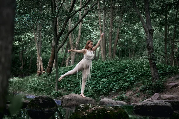 Porträtt av en vacker graciös blond kvinna som dansar. I skogen på sommaren. — Stockfoto