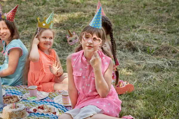 Flickor firar med karnevalsmasker. Roliga barn picknick med vänner. — Stockfoto