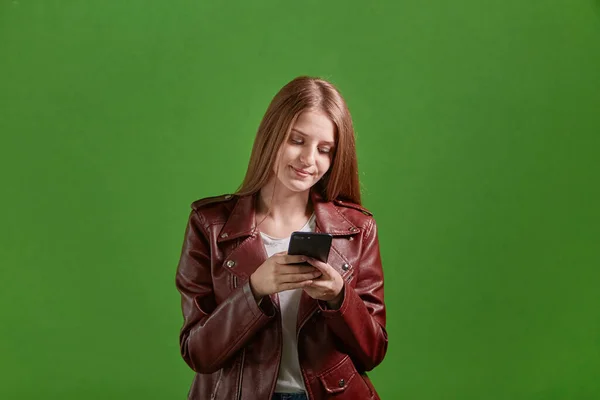 Una joven sostiene un smartphone y se comunica en las redes sociales. — Foto de Stock