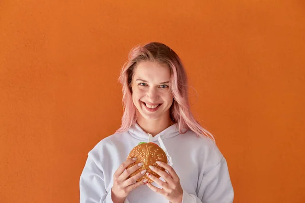 Šťastná mladá žena drží velký lahodný hamburger. Žena na dietě. — Stock fotografie