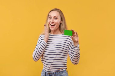 Genç, sarışın bir kadının elinde boş bir yeşil kart tutmasına şaşırdım..