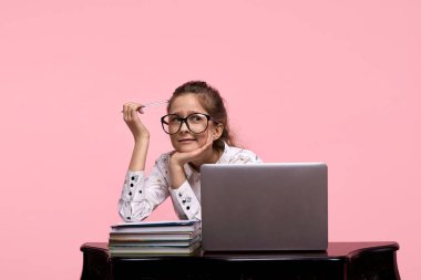 Pembe arka plandaki öğrenci önemli bir şey üzerinde çalışıyor ve düşünüyor..