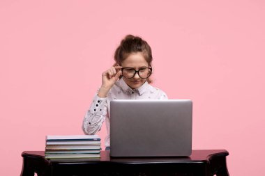 İnternete odaklan. Siyah çerçeveli gözlüklü genç bir kız internette çalışıyor..