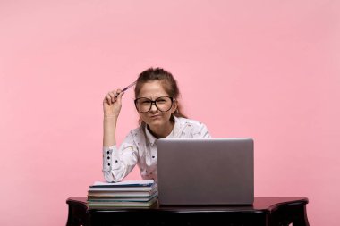 Kız, büyük gözlüklü ve beyaz gömlekli bir öğrenci, alnına bir kalem koy.