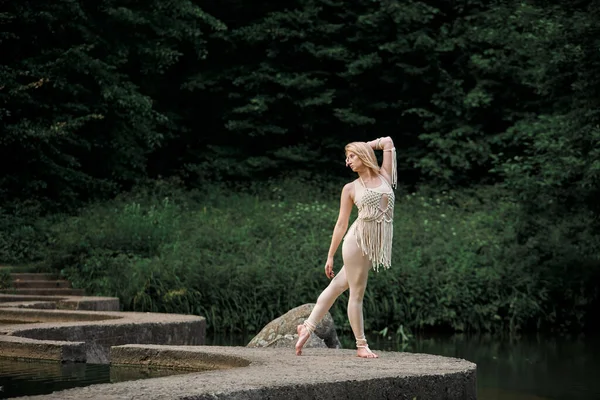 Jeune femme blonde dansant pieds nus sur un pont en béton sinueux. — Photo