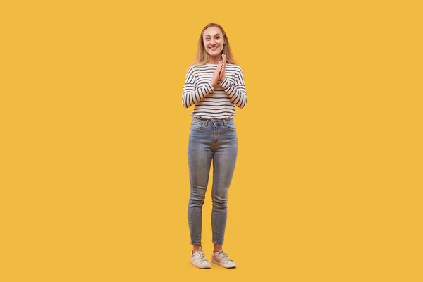 Beautiful happy woman smiles and looks at the camera, in full-length jeans. — Stock Photo, Image