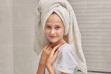 Beyaz havlu ve tişört giymiş güzel bir kızın portresi..