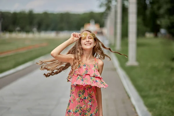Long blonde hair fluttering in the wind, the girl smiles, looks into the frame. — 스톡 사진