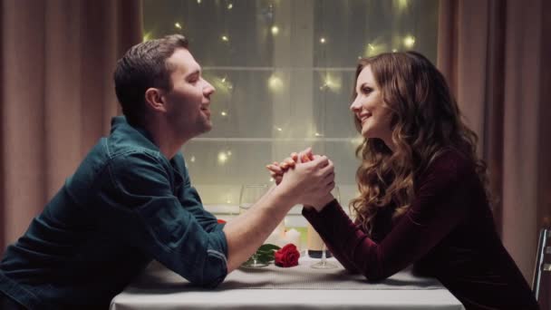 Un uomo e una donna si tengono per mano e baciano le donne. Cena romantica. — Video Stock