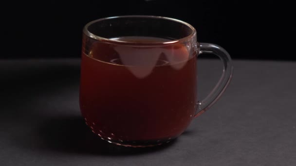 Mléko se nalévá do čirého šálku černého čaje. Vařit ovocný čaj. — Stock video