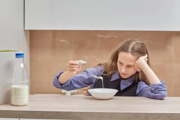 Stanca ragazza triste doesnt vuole mangiare cornflakes con il latte al mattino. — Foto Stock