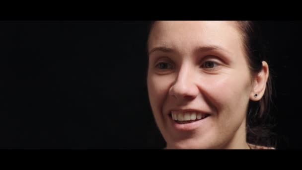 Portret van een mooie gelukkige jonge vrouw, glimlachend en kijkend naar de camera. — Stockvideo