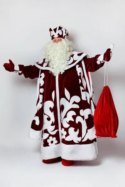 Papai Noel russo em pleno crescimento em um casaco de peles vermelho e com um saco de presentes. — Fotografia de Stock