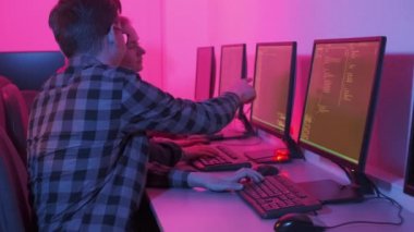 Bir adam genç bir kadına nasıl yapılacağını gösterir ve monitörü gösterir..