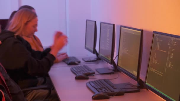 Programmierer, ein Mann und drei Frauen, machen sich an die Arbeit und tippen schnell auf die Tastatur. — Stockvideo