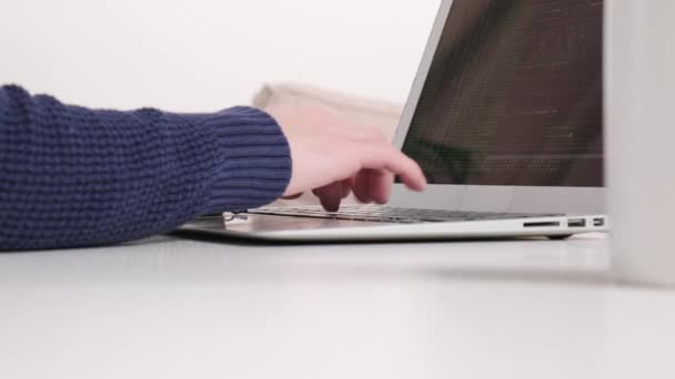 Un hombre trabaja en una oficina en un portátil. Imprime texto en el teclado del portátil. — Vídeos de Stock