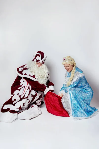 Санта Клаус и Снегурочка выносят подарки в большой красной сумке, костюмированной вечеринке. — стоковое фото