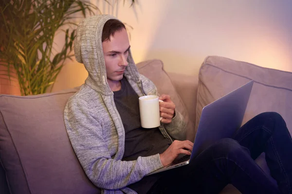 A man works at home online and drinks hot coffee. Working during a pandemic.