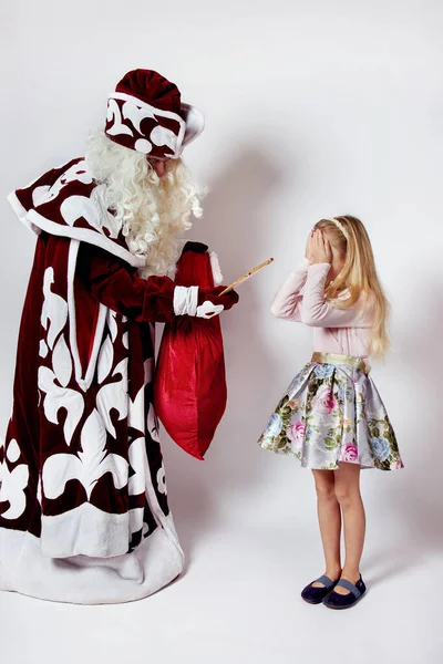 Père Noël donne un cadeau pour une petite fille les yeux fermés. — Photo