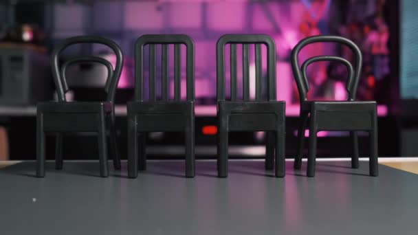 Gros plan de quatre chaises sombres à dossier haut. Fond avec une image rose et floue — Video