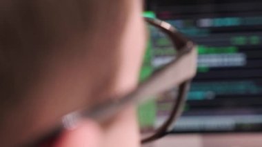 Arkasından, programcı gözlüklü bir adama bulanık bir görüntü. 4k video.