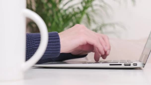 Hands of a young man who is typing text on a laptop. — Stock Video