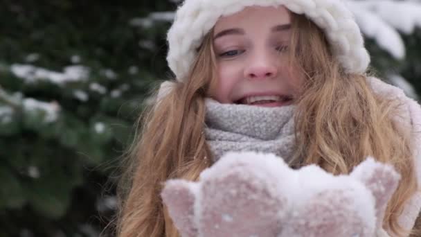 Egy szőke nő rózsaszín kesztyűs hóval játszik. Hó a kesztyűn. Lassú mozgás.. — Stock videók