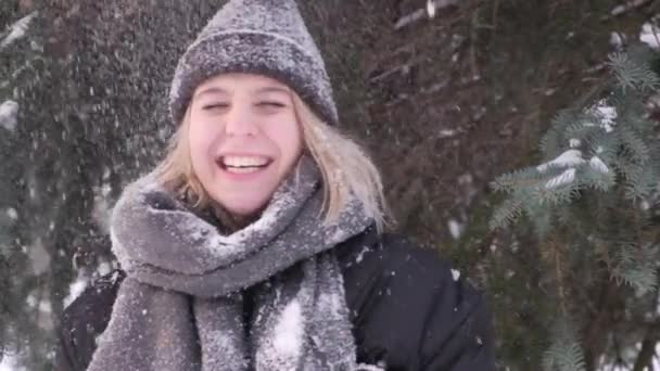 A neve cai em cima de uma jovem mulher de um ramo de abeto. Movimento lento. — Vídeo de Stock