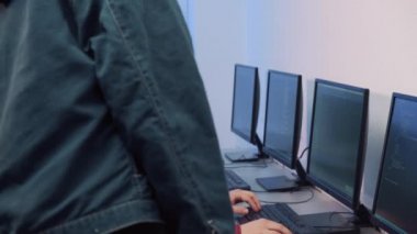 Genç bir adam, bir programlama okulunda genç kız öğrencilere programlama öğretiyor..