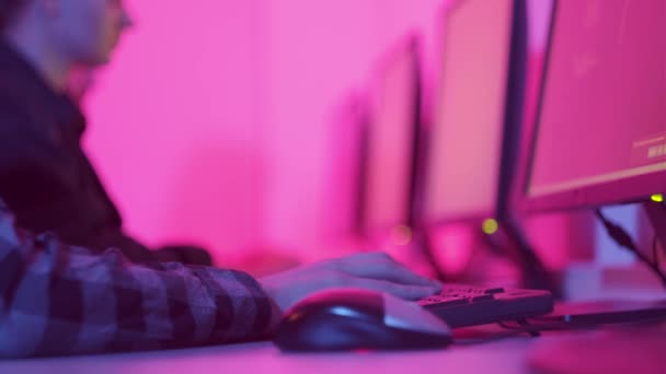 Um grupo de pessoas trabalha no escritório à noite. Luz rosa brilhante. — Vídeo de Stock