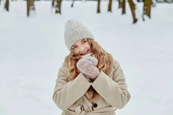 A lovely woman in a knitted hat and fur coat, smiling and looking at the camera. — Stock Photo, Image