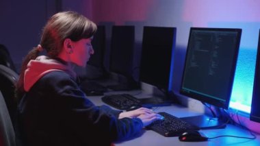 Hüsrana uğramış bir kadın programcı bir bilgisayarda çalışıyor. Mavi ve kırmızı arka plan.