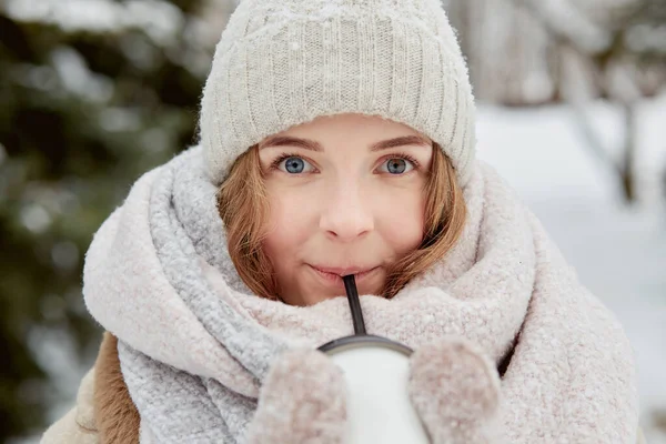 Portrét mladé krásné ženy v pleteném bílém klobouku. Zimní park. — Stock fotografie