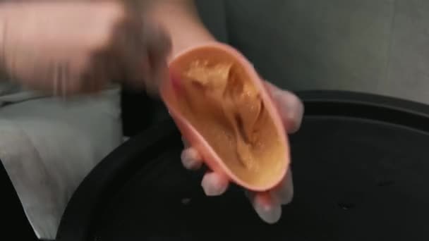 En las manos de una mujer, un recipiente de silicona con una máscara, crema, color naranja. — Vídeo de stock