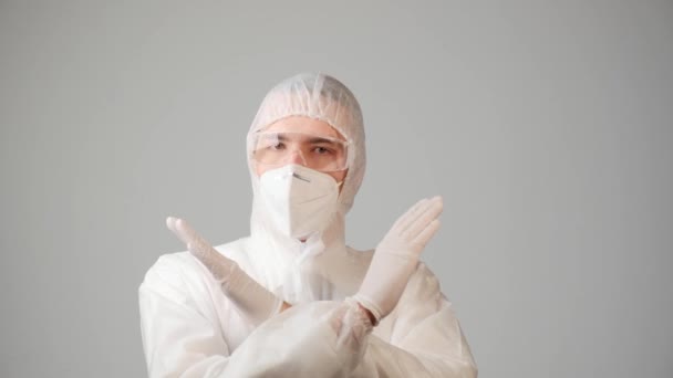 Un medico maschio in una tuta protettiva mostra un gesto proibito. — Video Stock