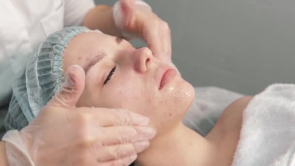 Profesyonel bir kozmetikçi müşterilerin yüzüne temiz bir temizlik jeli sürer.. — Stok video