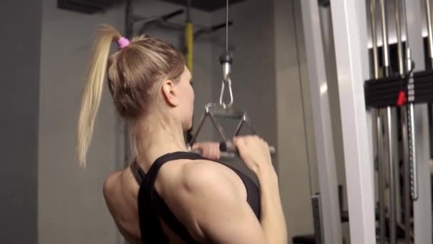 운동 선수인 여자가 손 시뮬레이터로 운동을 하고 팔에 근육을 얹고 운동을 한다. — 비디오