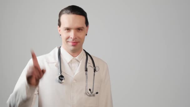 O jovem médico mostra um gesto de mão e balança o dedo para os lados. — Vídeo de Stock