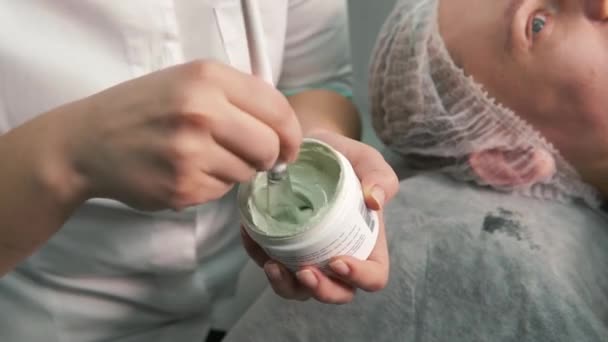 Kobiecy ręka kosmetolog typ zielony krem-żel z pędzel. Salon piękności — Wideo stockowe