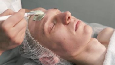 Güzellik uzmanının elleri yüzüne doğal yeşil kil sürmüş..