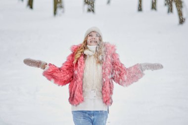 Kış parkında güzel bir kadın kar yağışı altında duruyor, bir sürü kar..