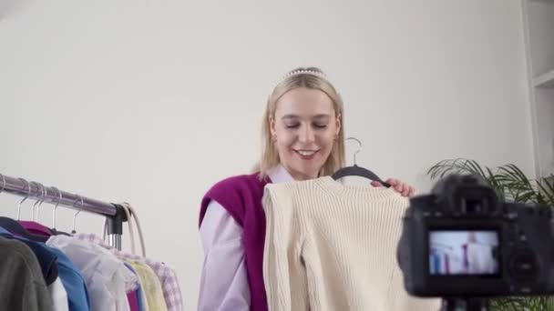 Una estilista femenina muestra y habla sobre la ropa delante de la cámara. — Vídeos de Stock
