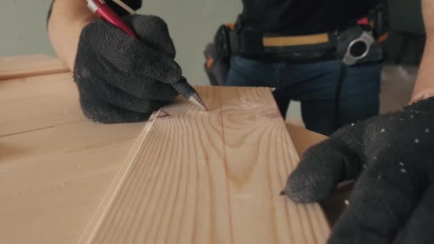 手袋をはめた建設労働者は赤い鉛筆で黒板に書きます。4kビデオ. — ストック動画