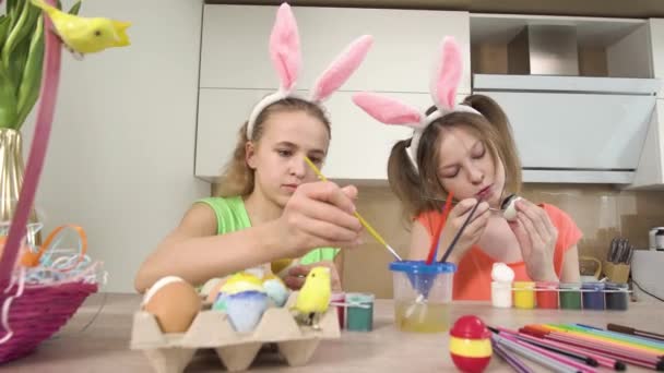 Deux amis décorent ensemble les œufs de Pâques avec de la peinture. Vacances de Pâques. — Video