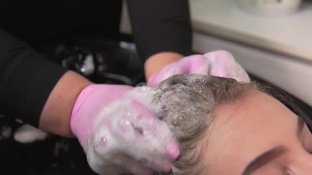 Το κομμωτήριο μασάζ κινήσεις αφρούς σαμπουάν στα βρεγμένα μαλλιά του πελάτη. — Αρχείο Βίντεο