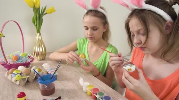 Meisjes versieren paaseieren met verf. Het meisje opent de gele verf.. — Stockvideo