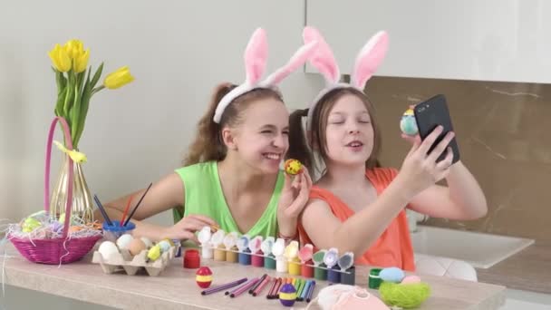 Girls with rabbit ears take selfies with a smartphone with Easter eggs. — Stock Video