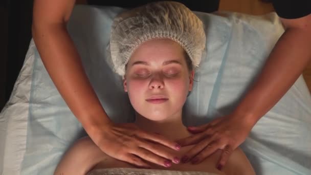 Piękna młoda kobieta korzysta z masażu szyi w klinice kosmetycznej. Widok z góry. — Wideo stockowe