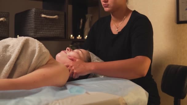 O massagista faz uma massagem anti-stress no pescoço com as mãos com óleo. — Vídeo de Stock