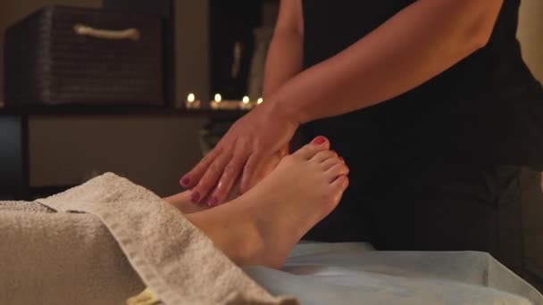 Detailní záběr masérových rukou, které masírují nohy a nohy kosmetickým olejem. — Stock video